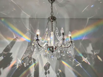 Chandelier crystal creating spectrum scatter on wall