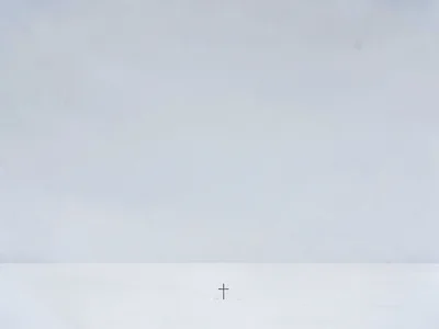 Tiny cross at bottom of vast arctic snow landscape