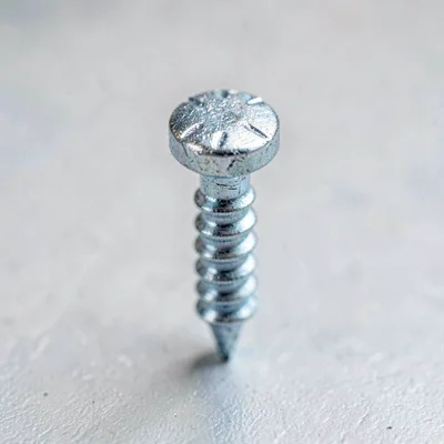 Macro of a galvanized joist hanger nail with hammer-marked head still bright