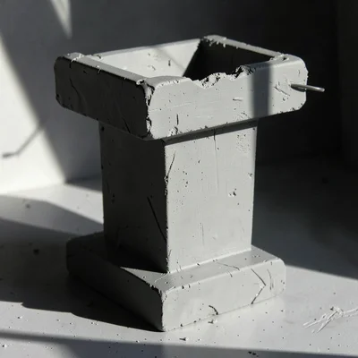 Heavy podium-shaped lectern carved as a single brutalist block, top edge slightl