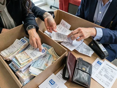 Tax professional surrounded by client receipt shoebox, the seasonal archaeology,