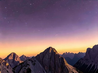 Ridge line teeth cutting into gradient from amber horizon to purple zenith