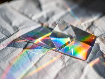 Cylindrical lens casting a rainbow line across a crumpled sheet of tracing paper