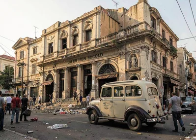 Mediterranean hard light on Beirut's wounded elegance, vintage Peugeot taxi pass
