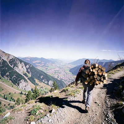High altitude photograph, thin mountain air, A woman carrying a load of firewood
