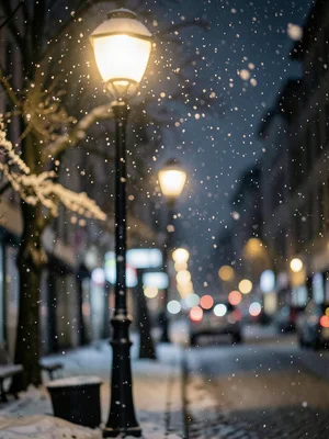 Snowflakes falling past streetlamp at night, shallow depth, peaceful