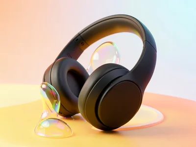 Sleek matte-black headphones tilted at a three-quarter angle on a buttery yellow