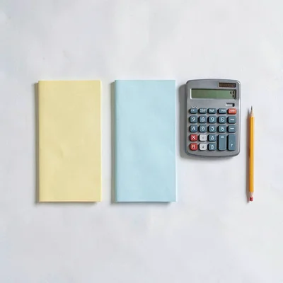 Flat lay of three folded forms beside a calculator and a sharpened pencil, neat