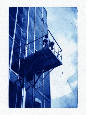 A window washer's platform suspended on the side of a glass tower