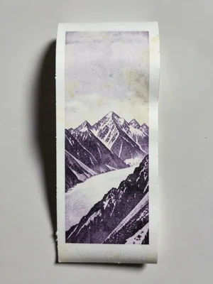 A mountain range printed on a long unspooled thermal receipt, paper curling and 