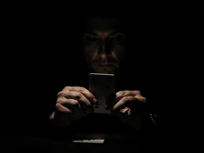 Hands dealing cards in darkness