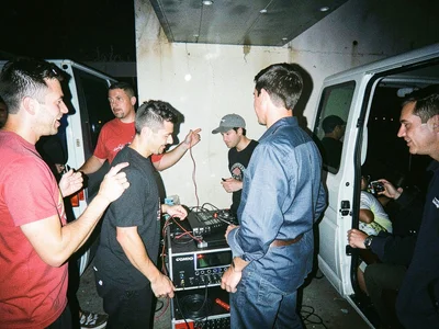 Band loading gear into a van at 2am