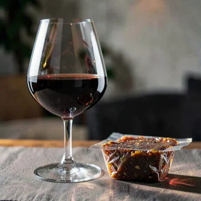 A glass of late-harvest wine beside a sealed terrine, deep amber liquor catching