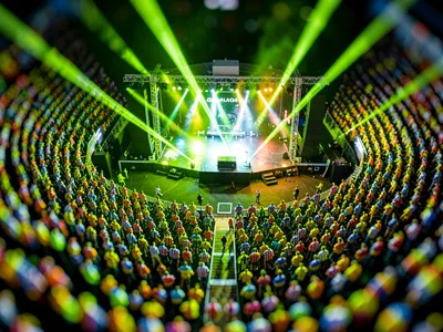 Grandstand tilt-shift photograph of an open-air concert, saturated chartreuse st