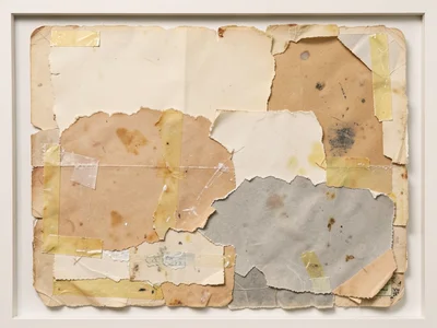 Layered torn papers with visible tape and glue marks, adhesive yellowed with age