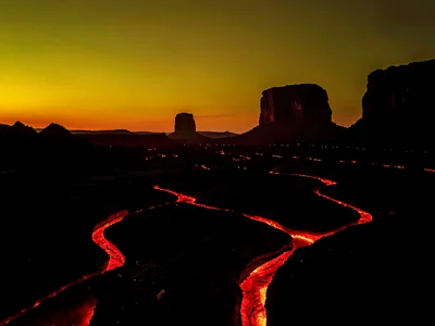 Volcanic obsidian plain at twilight with cooling lava fissures glowing crimson b