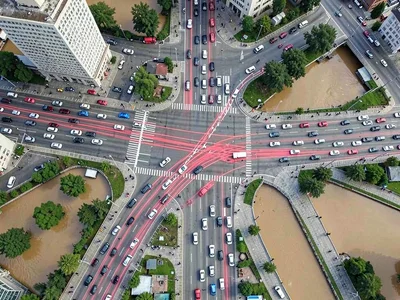 City intersection from above, twenty minutes of traffic creating red and white r
