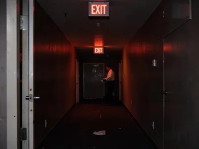 Wedding venue cleanup, last staff under EXIT sign, the post-celebration deflatio