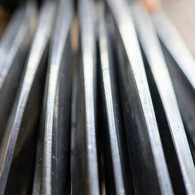 Vertical macro of a column of finished blades laid edge-up, light running each s