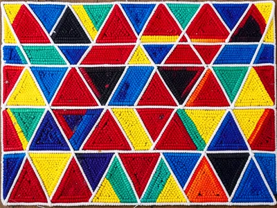 Beaded headband close-up — repeating triangular motif in blue, red, and yellow