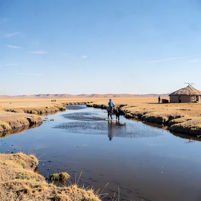 Gobi steppe horizontal, Mongolian vastness, Child riding yak across shallow rive