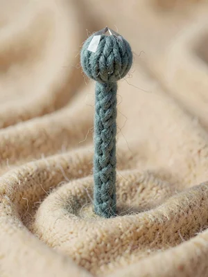 Tipped dusty-teal knit wizard-staff with a faceted bobble crystal at the head, o