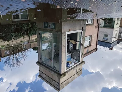 Phone booth reflected in puddle