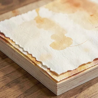 Warm illustration of a stack of fine art paper sheets with a deckled edge, butte