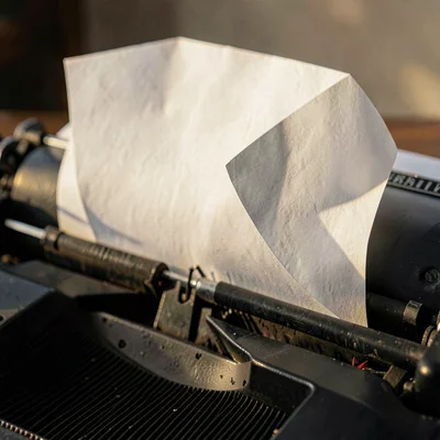 Folded paper composition resembling a curled sheet emerging from a typewriter, d