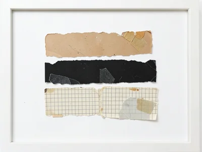 Minimal collage: three torn paper strips on white background, one kraft, one bla