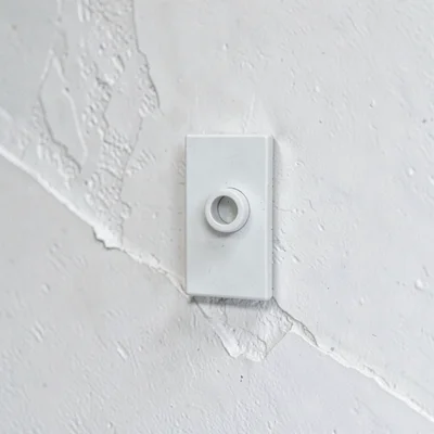 Mineralcut detail of a single starting block bracket against white plaster