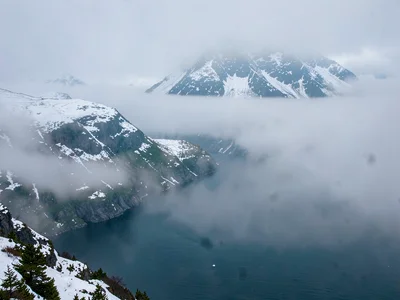Snow on ridges visible through clearing mist