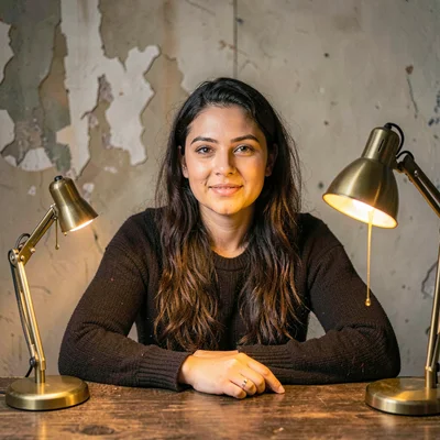 Warm character portrait of a growth lead seated at a quiet table, single brass l