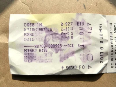 A receipt that has been left in the sun, the print half-faded to ghost impressio