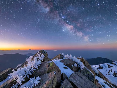 Frost crystals on summit rocks under twilight-to-space gradient