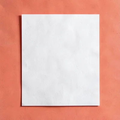 Sharp catalog hero of a single sheet of fine paper centered on a saturated coral