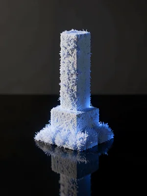 A hoar-fringe pillar standing alone on cold black glass, its hexagonal stack cat