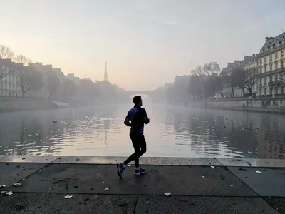 Morning jogger silhouette on foggy quay