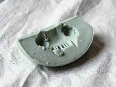 Wholly sage-green melon slice with a slumped rind and fingernail dimples on its 