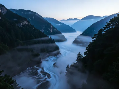 Fog waves spilling through mountain pass like water