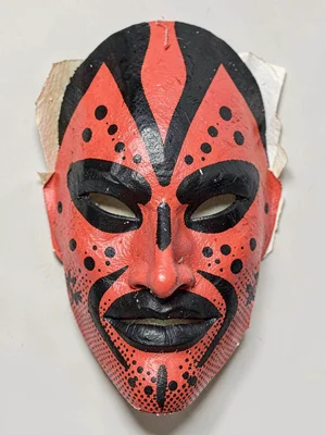 Tribal mask staring forward in red and black spot inks with bold halftone cheeks