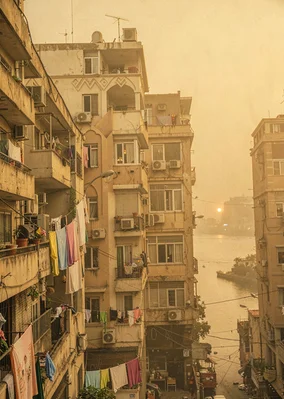 Dusty golden Cairo haze compressing apartment layers, downtown Cairo Art Deco fa