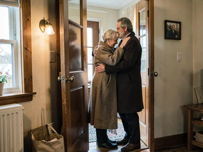 Person leaving family gathering, the grandmother's long hug in doorway, the when