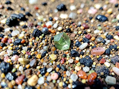Olivine crystal visible in volcanic beach sand