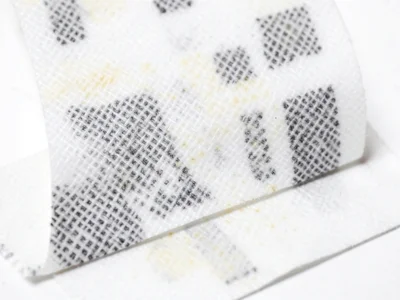 Receipt paper strip woven through itself in simple basket weave pattern, creatin