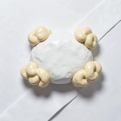 Fluffy chunky clay cloud-shaped pillow in primary white with stubby cream-toned