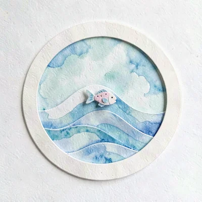 papercraft swimming badge with a folded paper wave and tiny fish