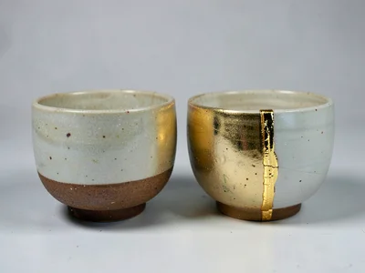 Two matching tea bowls — one whole, one repaired with gold — side by side