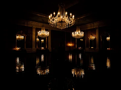Empty hotel ballroom drowned in chest-deep black water, crystal chandeliers half