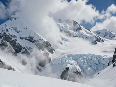 Avalanche in progress, full mountain face visible, scale of physics ignoring hum